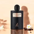 Maison Alhambra Opera Noir by Maison Alhambra 100ml EDP — Black textured bottle with gold label and deer logo, set against a soft peach background with shadows and small white flowers and dark pebbles. | Maison Alhambra Opera Noir by Maison Alhambra 100ml EDP — Botol hitam bertekstur dengan label emas dan logo rusa