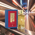 Maison Alhambra Renee Carmine EDP 100 ml Maison Alhambra — A gold perfume bottle and its blue and red box are displayed on a railing with a blurred background of a subway tunnel with streaks of light. | Maison Alhambra Renee Carmine EDP 100 ml Maison Alhambra — Sebotol minyak wangi emas dan kotak birunya dipamerkan di