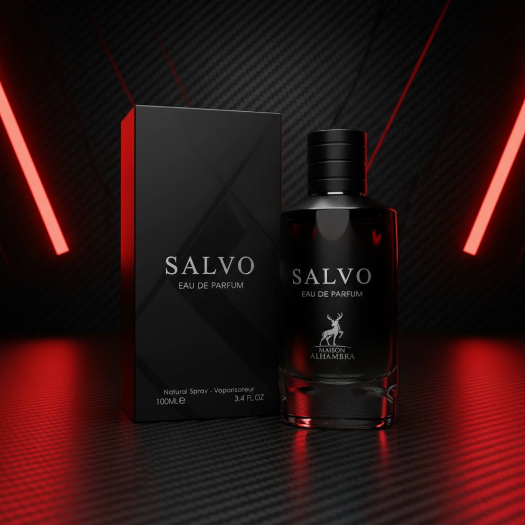Maison Alhambra Salvo by Maison Alhambra For Him 100ml — A black perfume bottle and its matching box stand on a dark, textured surface, illuminated by dramatic red neon lights against a carbon fiber-like background. | Maison Alhambra Salvo by Maison Alhambra For Him 100ml — Botol minyak wangi hitam dan kotaknya yang