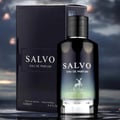 Maison Alhambra Salvo For Him Eau De Parfum — A dark, sleek perfume bottle with a black cap and a gradient label featuring a deer silhouette, standing next to its matching black box against a blurred, moody sky background. | Maison Alhambra Salvo For Him Eau De Parfum — Botol minyak wangi gelap yang ramping dengan