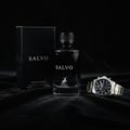 Salvo by Maison Alhambra For Him 100ml — A black box and a clear glass perfume bottle with a black cap and silver accents, alongside a silver and gold watch on a black fabric surface. | Salvo by Maison Alhambra For Him 100ml — Kotak hitam dan botol minyak wangi kaca jernih bertutup hitam dan perincian perak, bersama