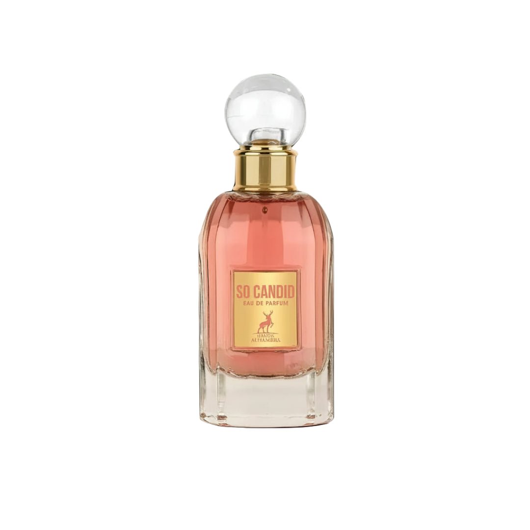 Maison Alhambra So Candid — A clear glass perfume bottle with pink liquid, a gold label featuring a deer, and a clear spherical cap, set against a white background. | Maison Alhambra So Candid — Botol minyak wangi kaca jernih dengan cecair merah jambu, label emas menampilkan rusa, dan penutup sfera jernih, berlatarkan