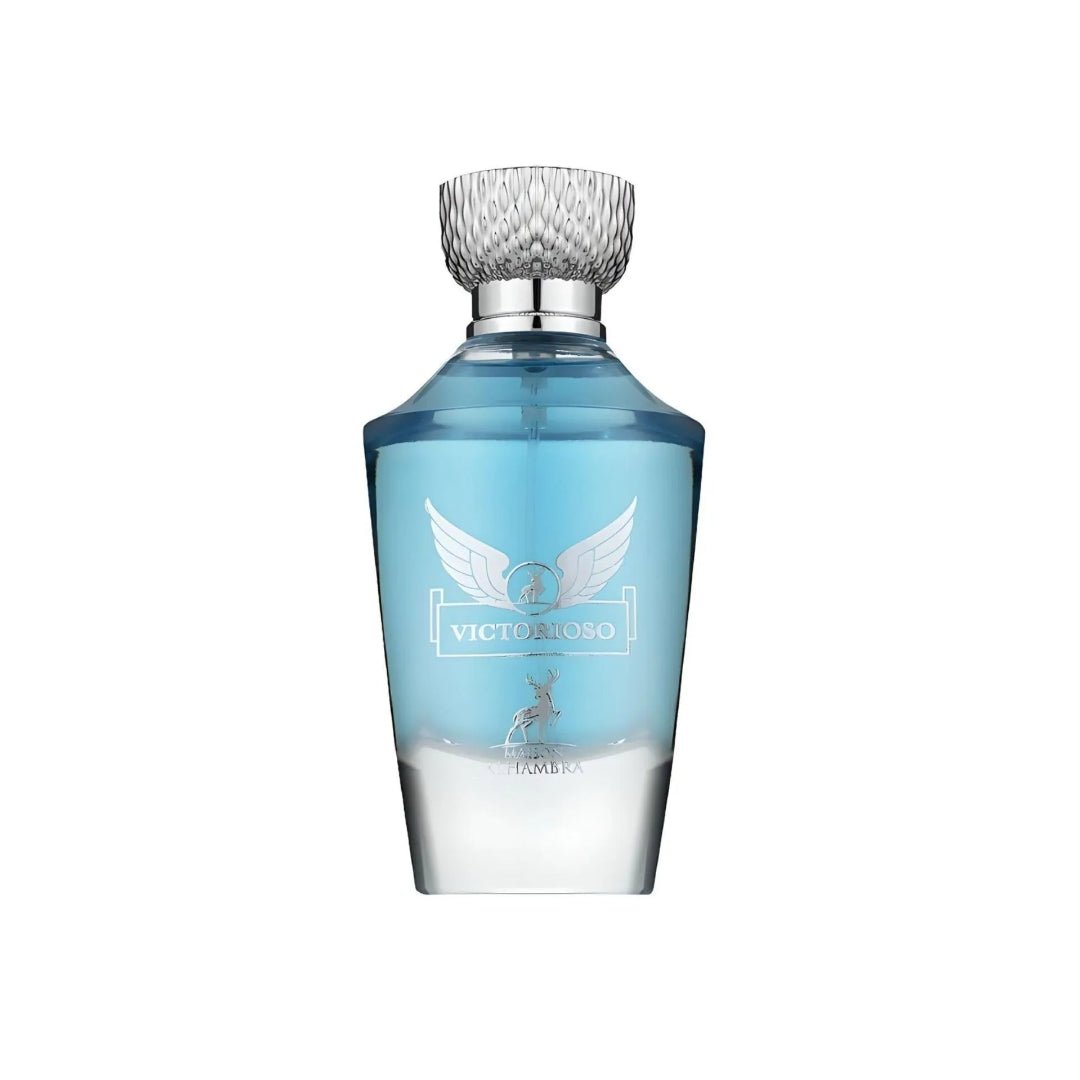 Maison Alhambra Victorioso by Maison Alhambra 100ml EDP Men — A clear glass perfume bottle with a light blue liquid and a silver cap, featuring a winged emblem and a deer silhouette on the front. | Maison Alhambra Victorioso by Maison Alhambra 100ml EDP Men — Botol kaca jernih dengan cecair biru muda dan penutup