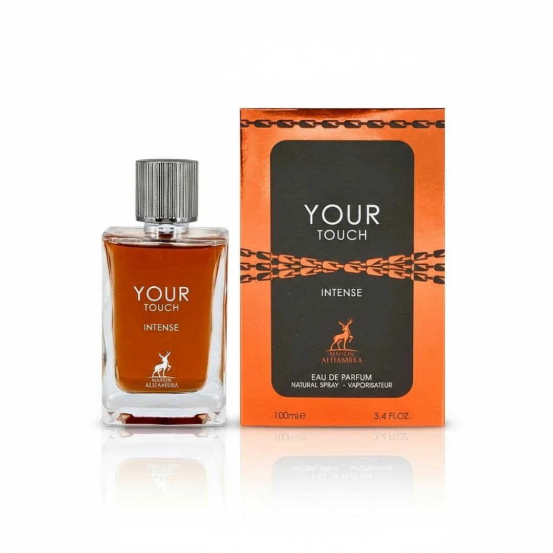 Maison Alhambra Your Touch Intense by Maison Alhambra 100ml — A clear glass perfume bottle with amber liquid and a silver ribbed cap sits next to its orange and black box with chain-link design. | Maison Alhambra Your Touch Intense by Maison Alhambra 100ml — Botol kaca jernih dengan cecair ambar dan penutup bergaris