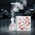 Maison Alhambra Luxe Chic by Maison Alhambra – 100 ml Women — A white perfume bottle with red heart and lip pattern is shown with smoke emanating from its top, next to its matching white box with the same pattern. The bottle has a cracked glass effect on its side. | Maison Alhambra Luxe Chic by Maison Alhambra – 100